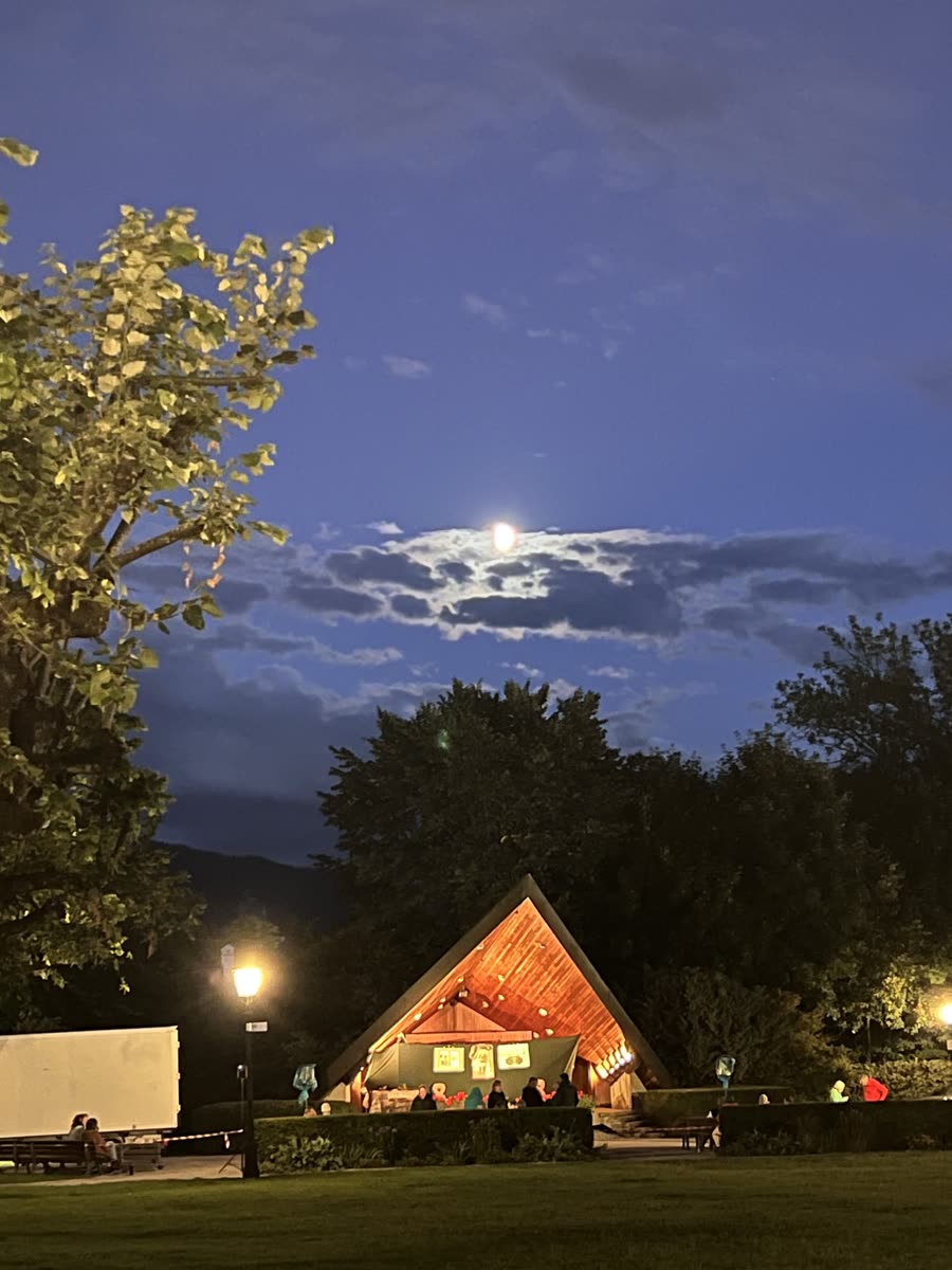 Die Freilichtbühne im Kurgarten Tegernsee am Abend des 22. August 2026, beleuchtet unter dem aufgehenden Mond